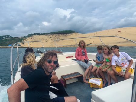 Une famille de touristes apprécie une balade en bateau le long de la dune du Pilat