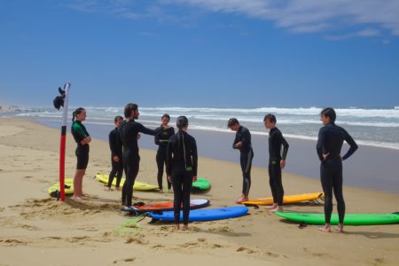 Moniteur de surf expliquant les consignes à ses élèves sur la plage du Cap Ferret